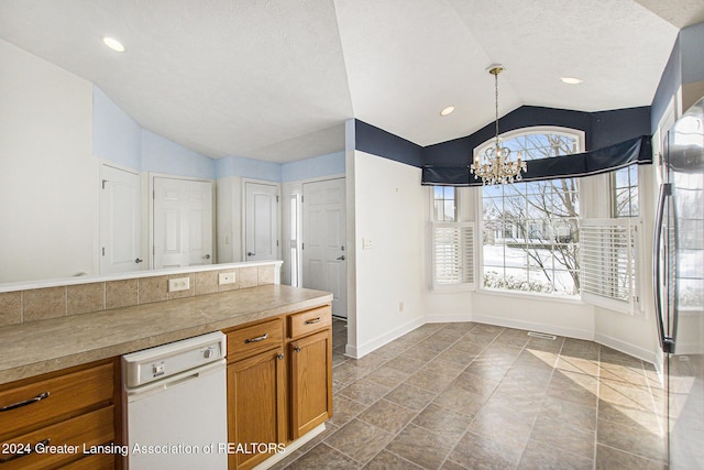 kitchen with a textured ceiling, an inviting chandelier, pendant lighting, and vaulted ceiling