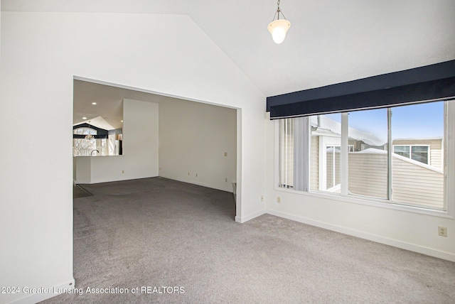 spare room with vaulted ceiling and light carpet