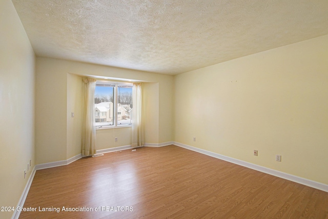 spare room with hardwood / wood-style floors and a textured ceiling