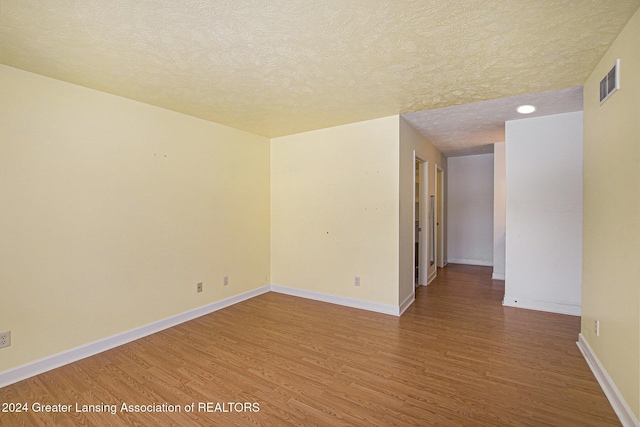 spare room with wood-type flooring and a textured ceiling