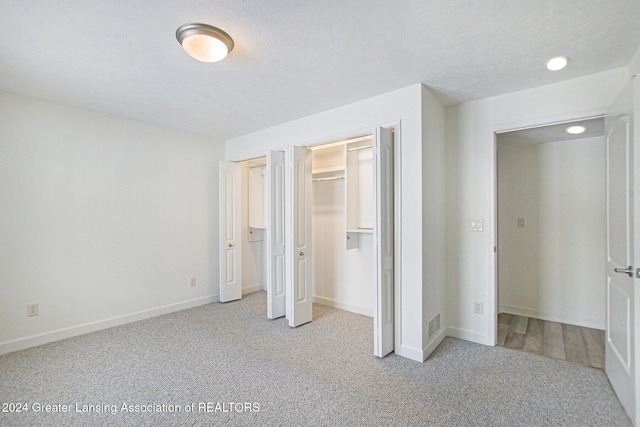 unfurnished bedroom featuring light carpet and a textured ceiling