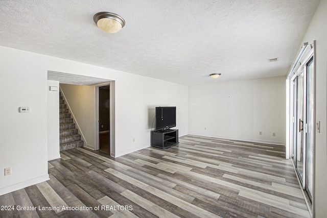 unfurnished living room with hardwood / wood-style floors and a textured ceiling