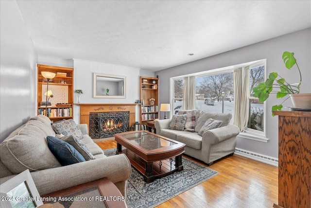 living room with a baseboard radiator and light wood-type flooring