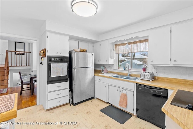 kitchen with tasteful backsplash, sink, black appliances, and white cabinets