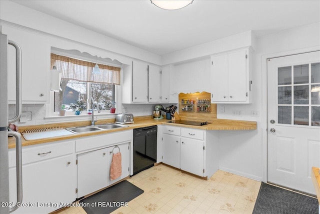 kitchen featuring white cabinetry, dishwasher, sink, and stainless steel fridge