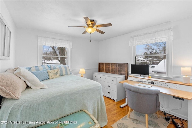 bedroom with multiple windows, ceiling fan, and light wood-type flooring