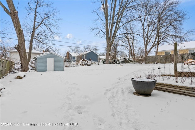 yard covered in snow featuring a storage shed