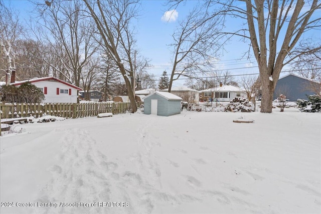 yard covered in snow with a storage shed