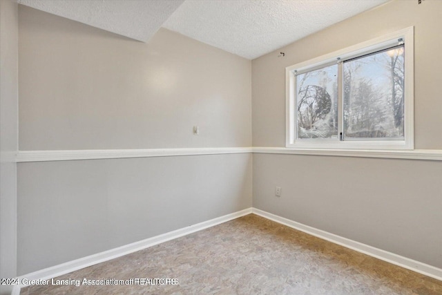 unfurnished room with a textured ceiling