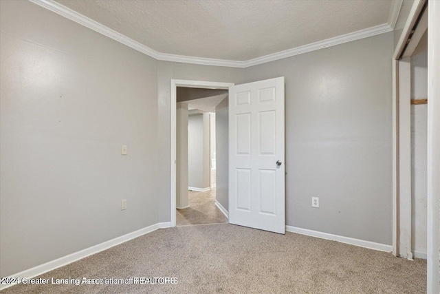 unfurnished bedroom featuring a textured ceiling, light colored carpet, and ornamental molding