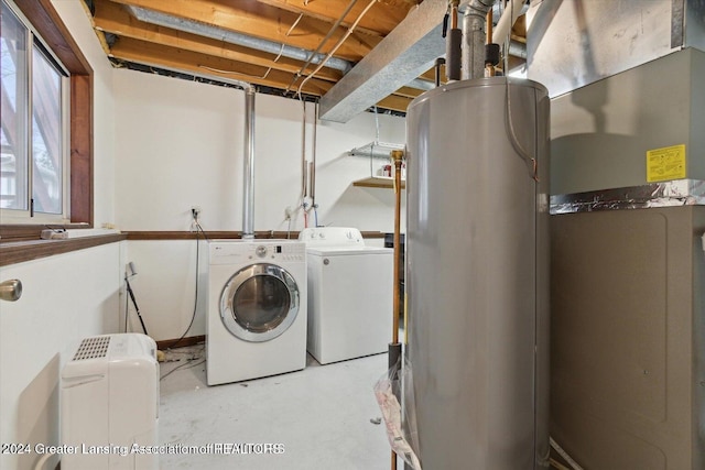 clothes washing area with separate washer and dryer and water heater