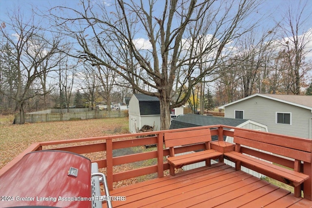 wooden terrace with a lawn and a shed