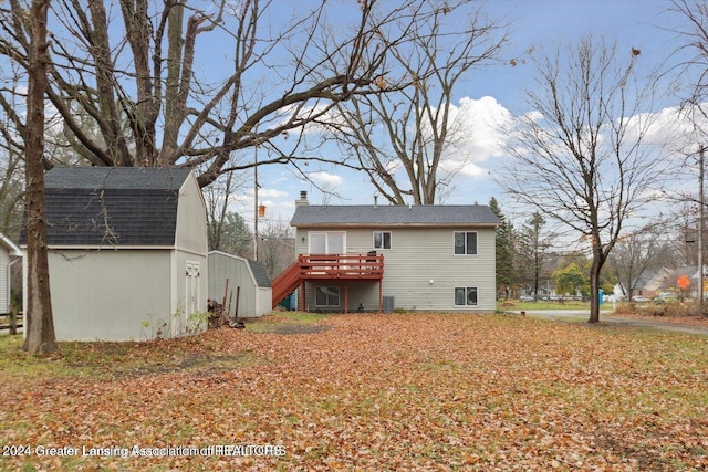 back of house featuring a wooden deck and a storage unit