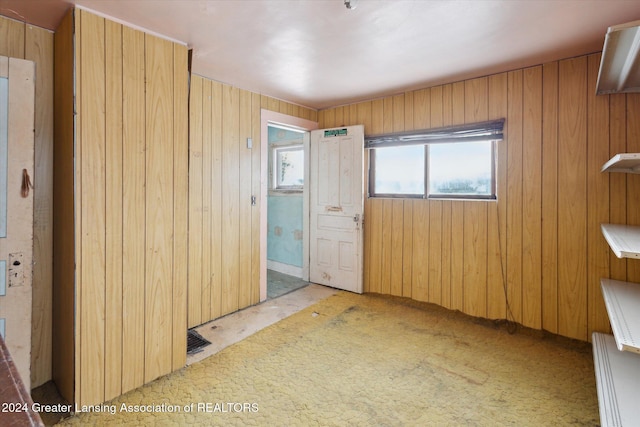 unfurnished bedroom with wood walls