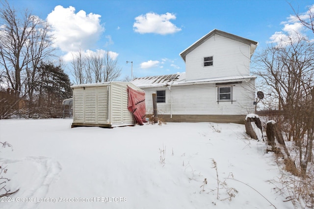 view of snow covered rear of property