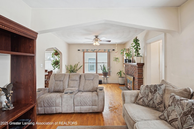 living room with ceiling fan, hardwood / wood-style floors, and a fireplace