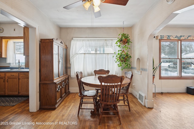 dining area featuring sink, light hardwood / wood-style floors, a healthy amount of sunlight, and ceiling fan