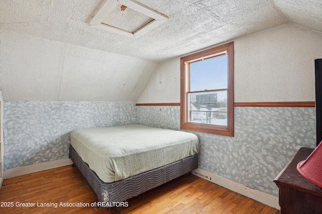 bedroom featuring lofted ceiling and wood-type flooring