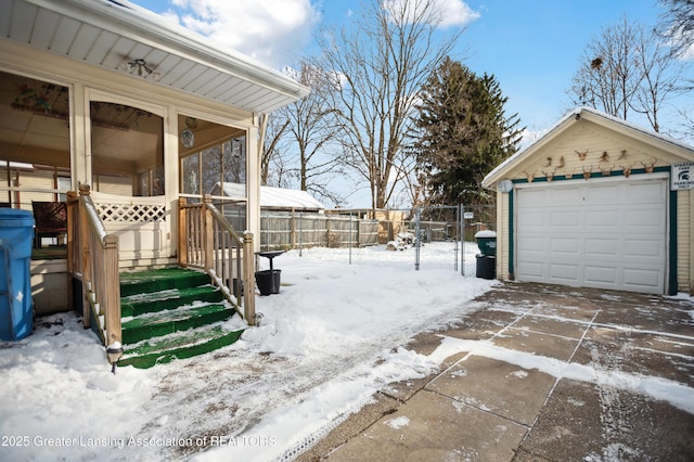 snowy yard with an outbuilding and a garage