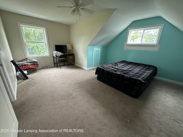 carpeted bedroom featuring multiple windows, vaulted ceiling, and ceiling fan