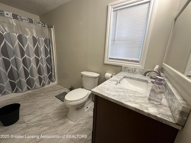 bathroom featuring walk in shower, vanity, and toilet