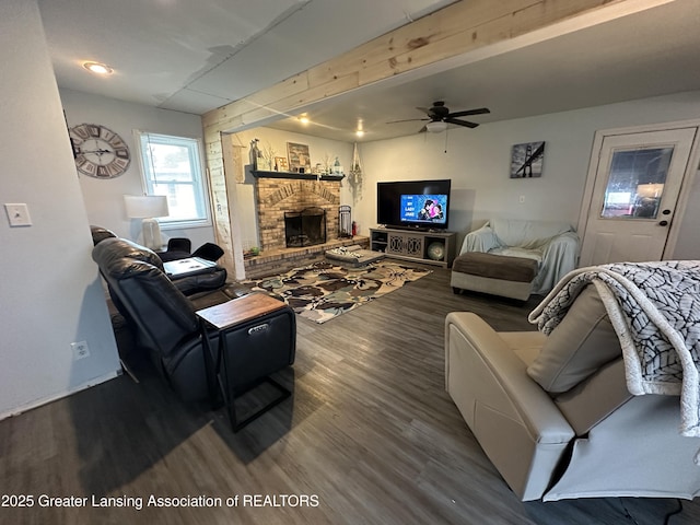 living room featuring beam ceiling, ceiling fan, hardwood / wood-style floors, and a fireplace