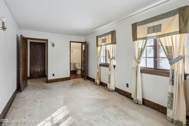 unfurnished bedroom featuring connected bathroom and carpet