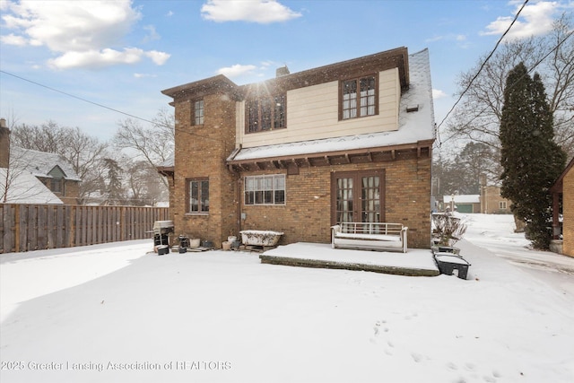 view of snow covered back of property