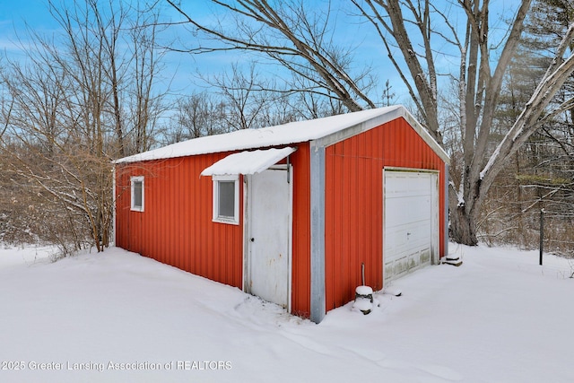 snow covered structure with a garage