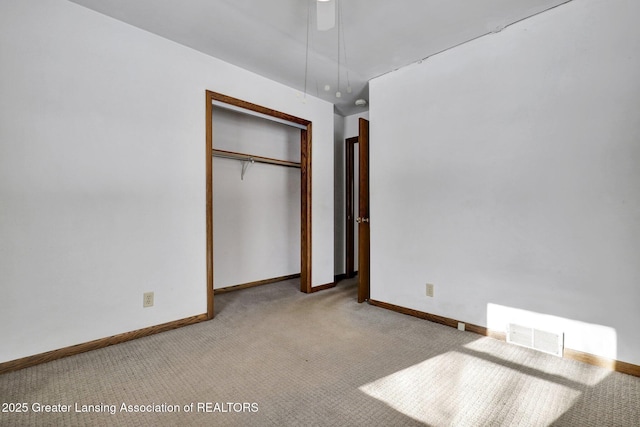 unfurnished bedroom with light carpet, ceiling fan, and a closet