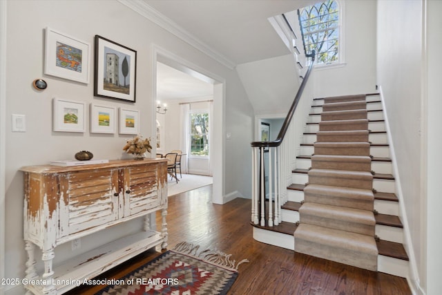 foyer entrance featuring dark wood-style floors, baseboards, stairs, and ornamental molding