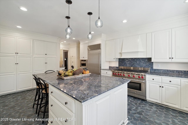 kitchen with decorative backsplash, white cabinets, a kitchen island, high quality appliances, and premium range hood