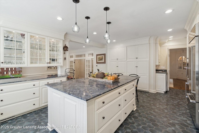 kitchen featuring glass insert cabinets, ornamental molding, white cabinets, and recessed lighting