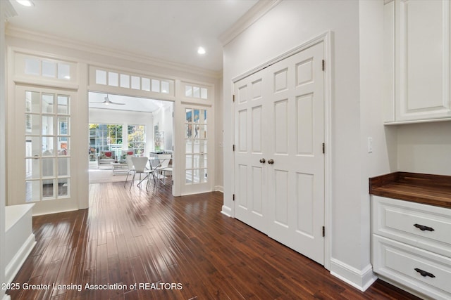 hall with baseboards, dark wood finished floors, crown molding, french doors, and recessed lighting