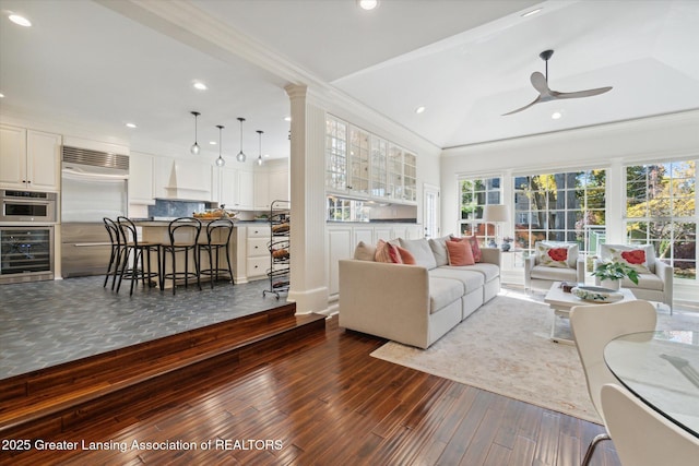 living area featuring wine cooler, ornamental molding, dark wood-style flooring, and recessed lighting