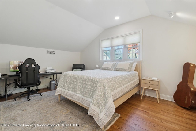 bedroom with lofted ceiling, wood finished floors, and baseboards