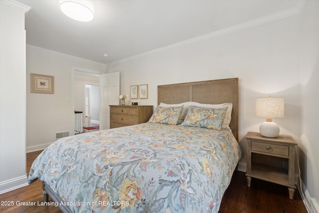 bedroom featuring visible vents, baseboards, wood finished floors, and ornamental molding