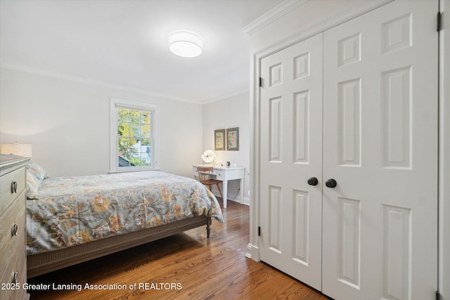 bedroom with crown molding and wood finished floors