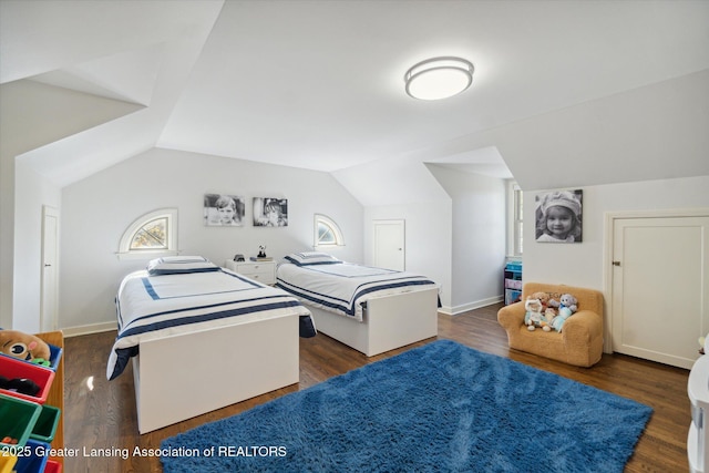 bedroom with lofted ceiling, baseboards, and wood finished floors