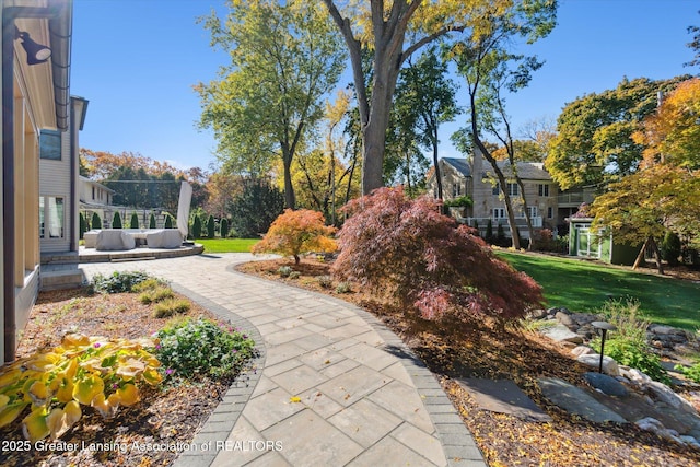 view of community with outdoor lounge area and a yard