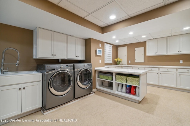 laundry area with independent washer and dryer, a sink, cabinet space, and recessed lighting