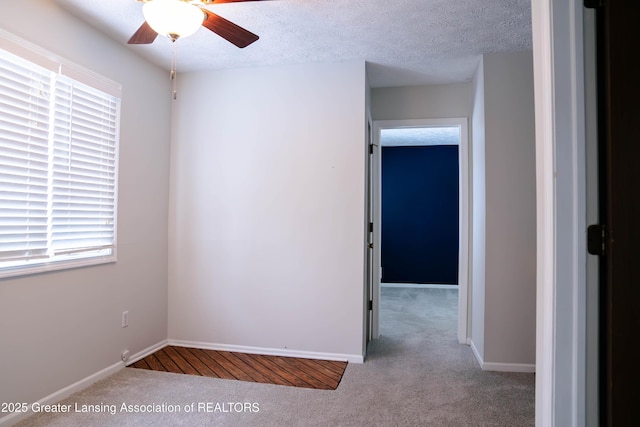 empty room with light carpet, ceiling fan, and a textured ceiling