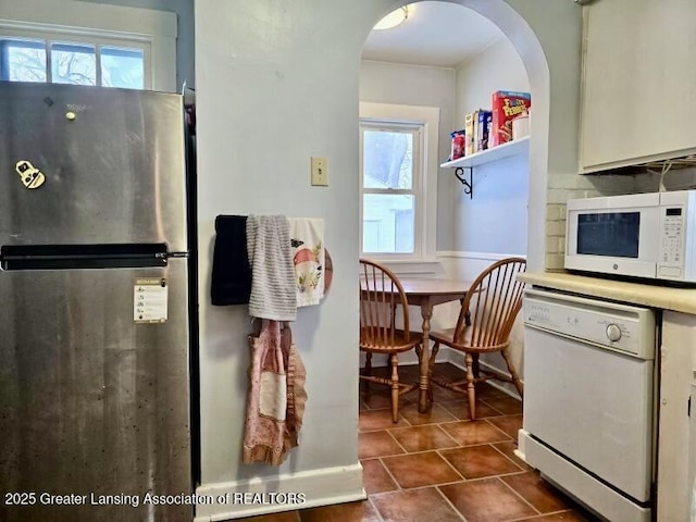 kitchen with dark tile patterned flooring and white appliances