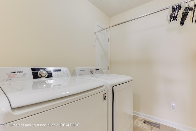 laundry area featuring laundry area, visible vents, baseboards, and washing machine and clothes dryer