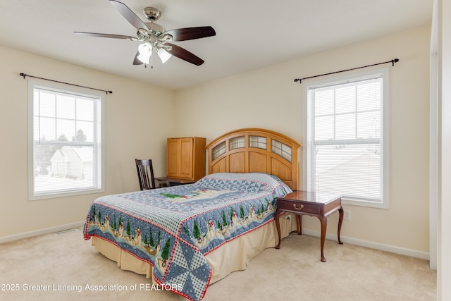 bedroom with ceiling fan, baseboards, and light colored carpet