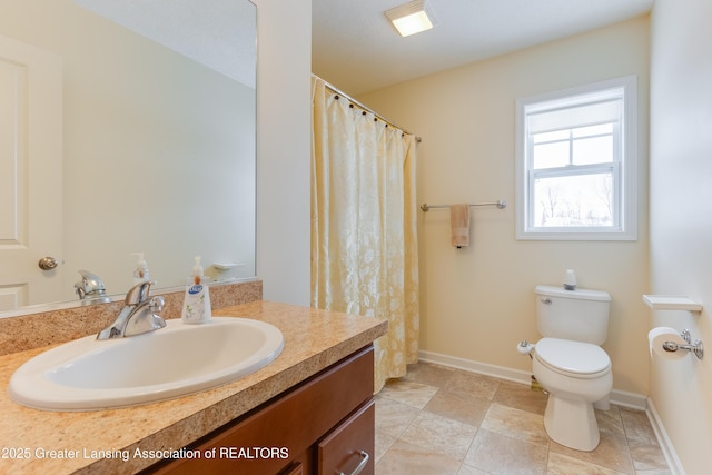 bathroom featuring toilet, baseboards, and vanity