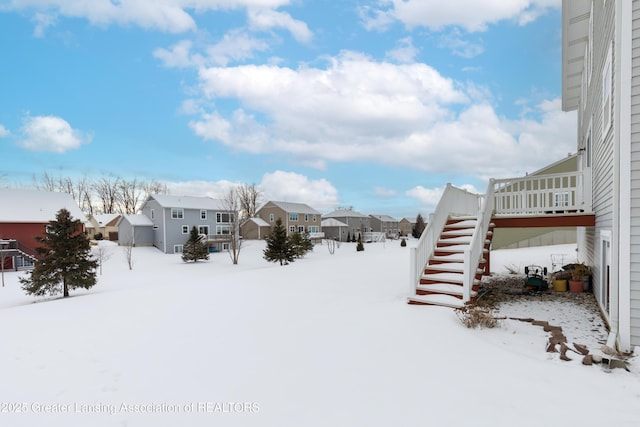 yard layered in snow with stairs, a residential view, and a deck