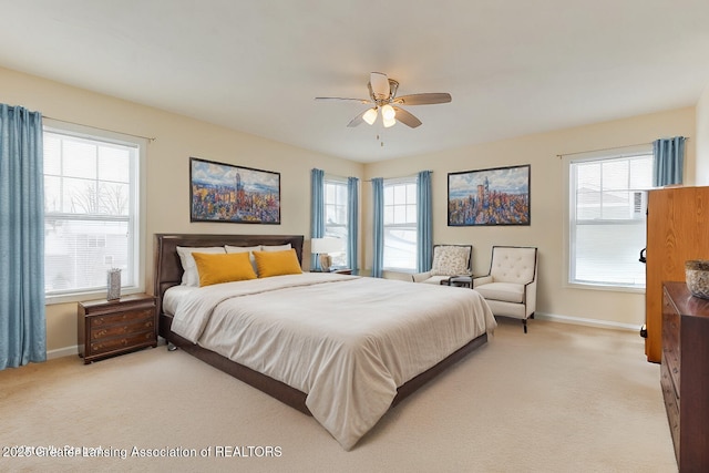 bedroom featuring light colored carpet, baseboards, and multiple windows