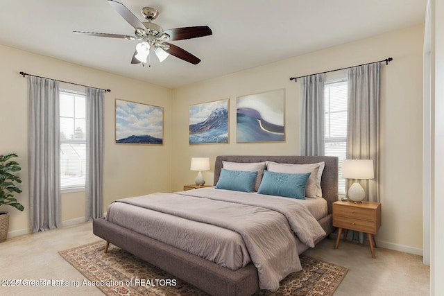 bedroom featuring light colored carpet, ceiling fan, and baseboards