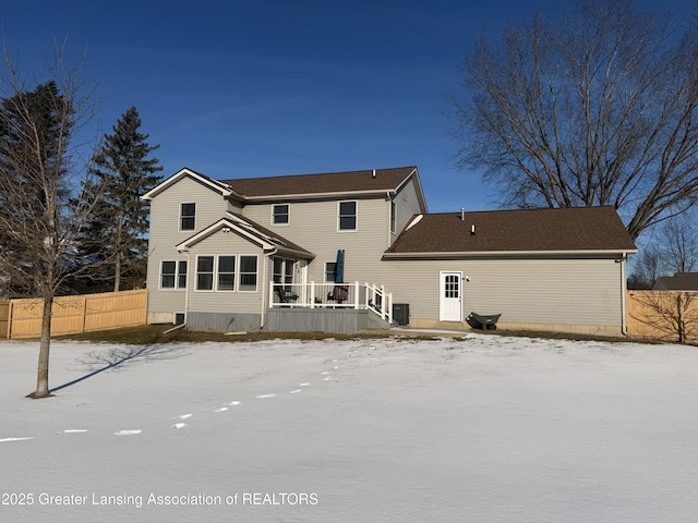 snow covered rear of property featuring a wooden deck